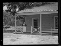Arline Chewning in front of a home created as part of a the Federal Project of Subsistence Homes, El Monte, 1935