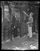 Detective Lieutenants Everett Harris and  Joe Gentry inspect fire damage to a boarding house, Los Angeles, 1935