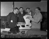 Judge A.A. Scott, William B. Hornblower, Charles W. Lyon and Frank Larco weighing a fish, Los Angeles, 1935