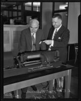 F.W. Robinson and A.V. Kipp inspecting telephotograver, Los Angeles, 1935
