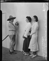 Martin Sipma holding a paint spray gun and talking with Mary Perrine and Patricia Coates on stage at the Hollywood Bowl, Los Angeles, 1935