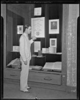 Ronald Mansbridge shows display case of rare books at Los Angeles Public Library, Los Angeles, 1935