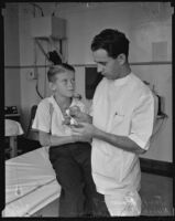 Nurse Price Pinkley bandaging John Price’s finger after being bitten by a squirrel, Los Angeles, 1935
