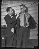 Richard Cantillon assisting F. Raymond Groves with his jacket, Los Angeles, 1935