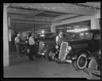 Three men inspecting three cars up for the Public Administrator's auction, Los Angeles, 1935