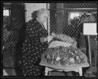 Elizabeth Styblik standing with silverware collection, Los Angeles, 1935