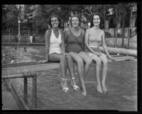 Olivia Redwine, Katherine Watkins, and Maxine White pose sit on a diving board wearing bathing suits, Los Angeles, 1935
