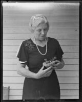 Edna Wedemeyer with a nest holding 2 baby bullfinches, Pasadena, 1935