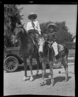 Mrs. Charles Atwood and Louis Vegar ride a horse and donkey during the San Gabriel Festival, San Gabriel, 1935