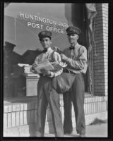 Retiring mailman, Marlon M. Wooldridge, and Alex Homyak stand outside the Huntington Park post office, 1935