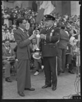 Ricardo G. Hill and Harry Signor holding a trophy together, 1935