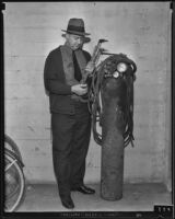 Police officer James Reid inspecting abandoned bank job equipment, Watts, 1935