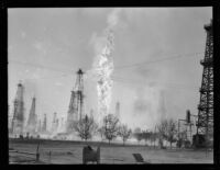 Oil well fire erupts in middle of oil field, Santa Fe Springs, 1935