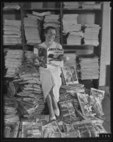 Peggy Mulligan poses atop a stack of magazines at the post office, Los Angeles, 1935