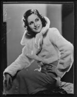 Actress Kay Hughes modeling a dress and fur jacket, Los Angeles, 1935