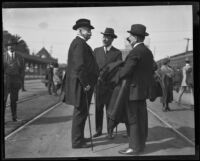 Henry E. Huntington with 3 men at a train station, 1920-1927