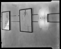 View of two framed fashion illustrations and an art deco sconce in "Irene LTD," a dress shop of designer Irene Lentz Gibbons, Los Angeles, (circa 1930?)