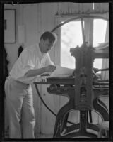Arthur Millier operating a rolling press, Santa Monica, 1930