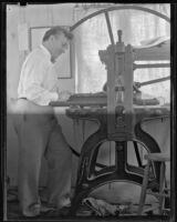 Arthur Millier operating a rolling press, Santa Monica, 1930