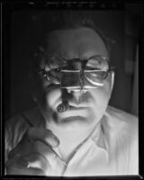 Man looking through a glasses with attached square lenses, 1930-1960