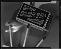 Three matches burning beneath a box of Ohio Blue Tip Matches, 1925-1939