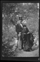 Man and woman, probably Dwight Gibbs and Alice Gibbs, in old fashioned dress in Olive Percival's Arroyo Seco garden, Los Angeles, 1940