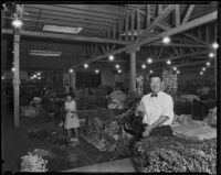 Vendor at the flower market waves to camera, Los Angeles, 1935