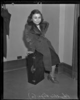 Twelve-year-old runaway Phyllis Liga poses on her suitcase, Los Angeles, 1936