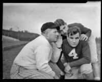 Coach whispering to football players, Los Angeles, 1938