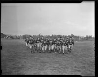 Twenty seven football players rush the field, Los Angeles, 1938