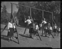 School children play outside on swings, Los Angeles, 1938