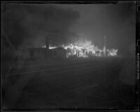 Structures on fire at Castle Rock Beach, Los Angeles, 1938