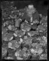 Santa Claus beside about 30 Christmas gift baskets of food at the Elks Club, Los Angeles, 1938