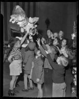 Santa Claus holds stuffed presents for a group of Children at the Elks Club, Los Angeles, 1928