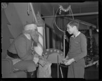 Boy receives a gift while visiting a Santa Claus, Los Angeles vicinity, 1938