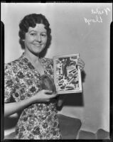 Violet Lloyd holding framed American Indian artifacts, 1938
