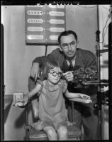 Dr. Ralph D. Ryan, optometrist, in his office with a little girl patient, Upland, 1938