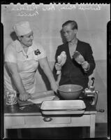 Lawrence Kick, member of the Chaffey Pigeon Club, holds 2 pigeons while Mrs. Rebecca Maxie rolls out a pie crust for a pigeon pie, Rancho Cucamonga, 1938