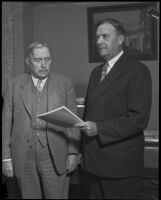 John C. Austin and Adolph Scheicher stand in an office, [Los Angeles?], [1920-1939]