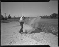 Jim Ross hitting a golf ball out of a sand trap, Los Angeles,