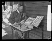 Arthur Sanger sits with a small display of Nicoleño artifacts excavated from San Nicolas Island, Los Angeles, 1928