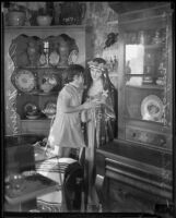 Adele Nissim with a statue of Santa Rosa di Lima in an antique shop, Los Angeles, 1920-1939