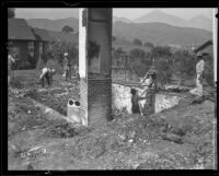 Men sift through and clean-up debris around the ruins of William and Clara Steele's ranch home, Pomona, 1921