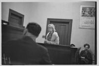 Night court at Lincoln Heights, a young woman at the judge's bench, Los Angeles, 1935