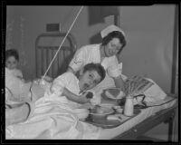 Nurse Dorothy Barkell helps Phillip Gurowitz with his Thanksgiving dinner at General Hospital, Los Angeles, 1935