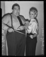 Mack Gordon, song writer, and Ruby Wood smile with satisfaction over his weight loss, Los Angeles, 1935