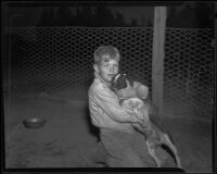 Chuck Drennon hugs a dog at the dog pound, Redondo Beach, 1935