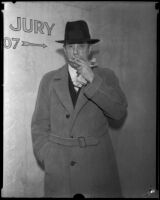 Kent K. Parrott, smoking a cigarette, summoned as witness in a gambling case, Los Angeles, 1935