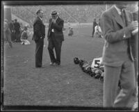 Stub Allison, assistant coach of the Golden Bears, talks with a man during a match with the USC Trojans at the Coliseum, Los Angeles, 1934