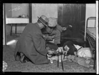 Two detectives search for evidence in the apartment of confessed kidnapper and murderer William Edward Hickman, Los Angeles, 1927